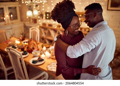 Happy African American couple embracing while celebrating Thanksgiving day at home. - Powered by Shutterstock