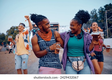 Happy African American couple having fun while being with friends on summer music festival. - Powered by Shutterstock