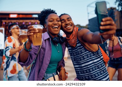 Happy African American couple having fun and taking selfie during music concert in summer.  - Powered by Shutterstock