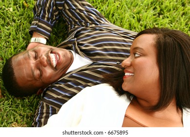 Happy African American Couple Laying On The Grass On A Park