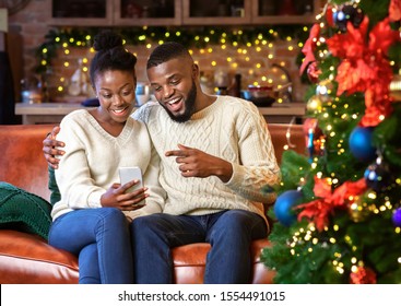 Happy african american couple making video call with smartphone, greeting their family with Christmas or New Year holidays. - Powered by Shutterstock