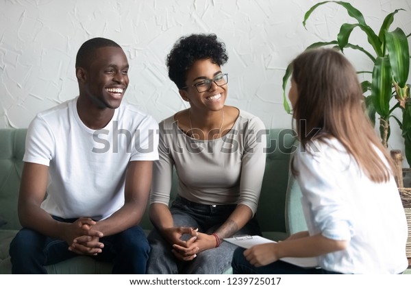 幸せなアフリカ系アメリカ人の夫婦は 心理学者の訪問に成功し 笑顔の妻と夫が 良い家庭療法の後 ソファに座り 顧客を満足させ 配偶者の問題解決に役立つ の写真素材 今すぐ編集
