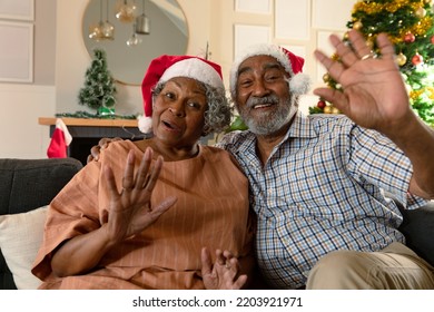 Happy african american couple wearing santa hats having video call at christmas time. christmas, festivity and communication technology at home. - Powered by Shutterstock