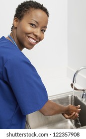 Happy African American doctor washing hands in washbasin