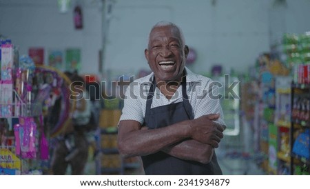 Happy African American employee and female customer laughing and smiling together standing by supermarket aisle. joyful authentic everyday people