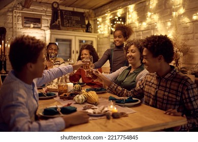 Happy African American Extended Family Toasting And Having Fun While Gathering For Thanksgiving Meal At Dining Table.