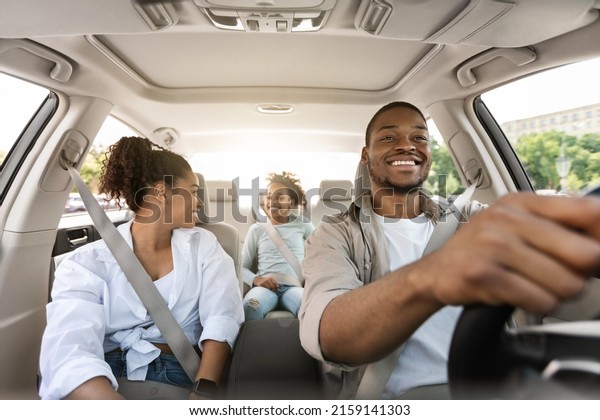 Happy African American Family Driving New\
Automobile Having Ride In City, Enjoying Road Trip. Parents And\
Daughter Spending Vacation Traveling By Car. Auto Purchase And\
Rent. Selective Focus