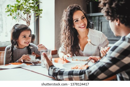 Happy African American Family Eating Lunch Together At Restaurant And Having Fun