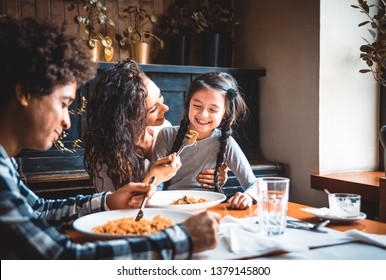 Happy African American Family Eating Lunch Together At Restaurant And Having Fun