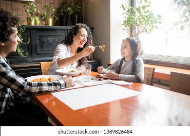 Happy African American Family Eating Lunch Together At Restaurant And Having Fun