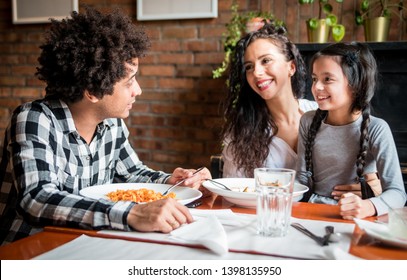 Happy African American Family Eating Lunch Together At Restaurant And Having Fun