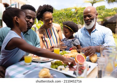 Happy African American Family Eating Brunch At Dining Table In Backyard. Family, Love And Togetherness Concept, Unaltered.