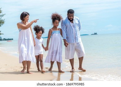 Happy African American Family With African American Father And Asian Mother And Mixed Race Kids Walking On The Beach, Thaliand