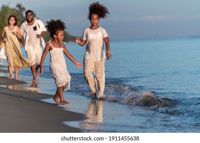 Happy African American Family With African American Father And Asian Mother And Mixed Race Kids Walking On The Beach, Thaliand