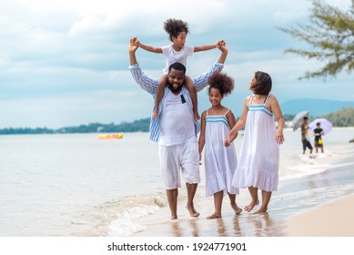 Happy African American Family With African American Father Asian Mother And Mixed Race Kids Walking On The Beach, Thaliand