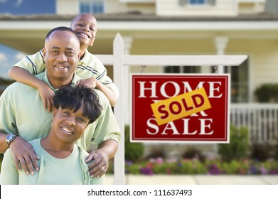 Happy African American Family In Front Of Sold Real Estate Sign And House.