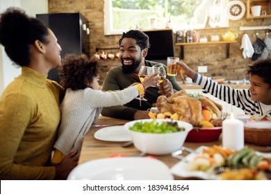 Happy African American Family Having Fun While Toasting During Thanksgiving Meal In Dining Room. 