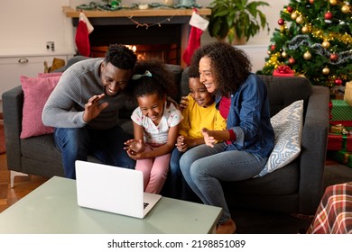 Happy African American Family Having Video Call On Laptop, Christmas Decorations In Background. Christmas, Festivity And Communication Technology.