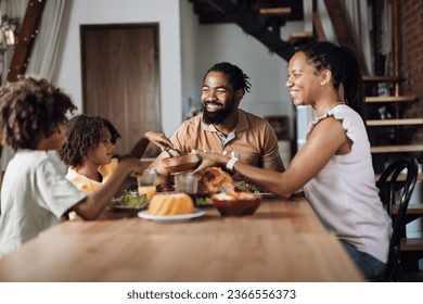 Happy African American family  having Thanksgiving lunch at dining table - Powered by Shutterstock