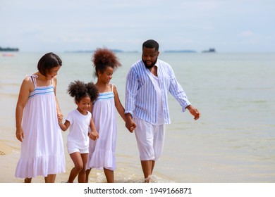 Happy African American Family Holding Hands And Walking Together On The Beach During Holiday.