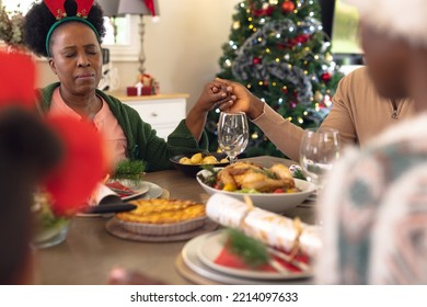 Happy African American Family Praying Before Having Christmas Meal. Christmas, Family Time And Celebration Concept.