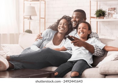 Happy african american family relaxing and watching tv at home, enjoying weekend together. - Powered by Shutterstock