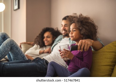 Happy African American Family Relaxing And Watching Tv.