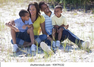 Happy African American Family Sitting Outside Together Having Fun In Sunshine