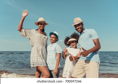 Happy African American Family Smiling At Camera And Showing Thumbs Up On Beach