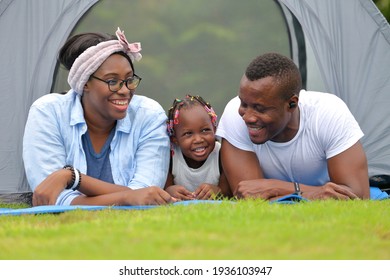 Happy African American family spending time together during vacation on the camping tent outdoor national park