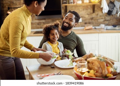 Happy African American Family Talking During Thanksgiving Meal In Dining Room. 