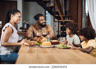 Happy African American  family talking during lunch time at dining table - Powered by Shutterstock