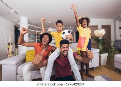Happy african american family watching soccer match on television in living room at home. - Shutterstock ID 1978420274