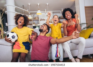 Happy African American Family Watching Soccer Match On Television In Living Room At Home.