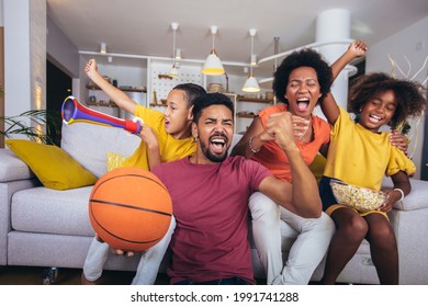 Happy African American Family Watching Tv And Cheering Basketball Games On Sofa At Home.