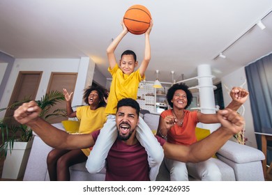 Happy African American Family Watching Tv And Cheering Basketball Games On Sofa At Home.