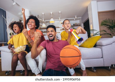 Happy African American Family Watching Tv And Cheering Basketball Games On Sofa At Home.