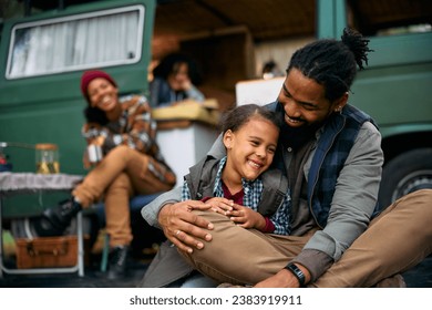 Happy African American father and daughter having fun during picnic at camper trailer park. - Powered by Shutterstock