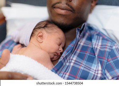 happy african american father holding newborn baby in hospital