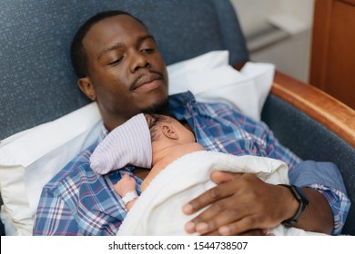 happy african american father holding newborn baby in hospital