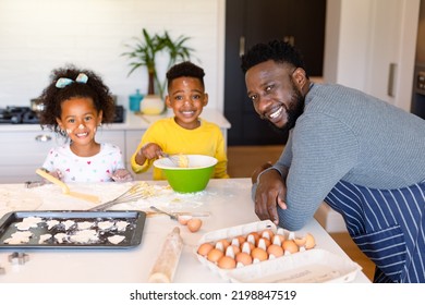 Happy african american father and siblings baking together in kitchen. baking and cooking, family time, having fun together at home. - Powered by Shutterstock