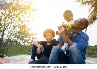 Happy African American father, son and daughter enjoying joyful moment together in the outdoor park