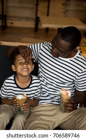 Happy African American Father And Son Eating Ice Cream And Having Fun In Cafe