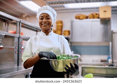 Happy African American female chef working in the kitchen in a restaurant and looking at camera. - Powered by Shutterstock