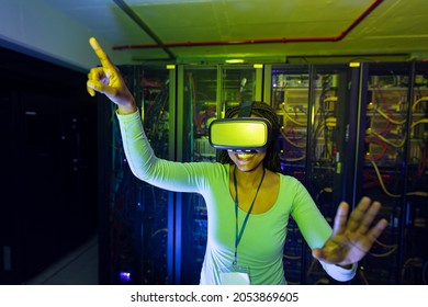 Happy african american female computer technician wearing vr headset and working in server room. digital information storage and communication network technology. - Powered by Shutterstock