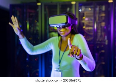 Happy african american female computer technician wearing vr headset and working in server room. digital information storage and communication network technology. - Powered by Shutterstock