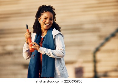 Happy African American Female Sports Fan Having Fun With Vuvuzela Outdoors And Looking At Camera. Copy Space. 