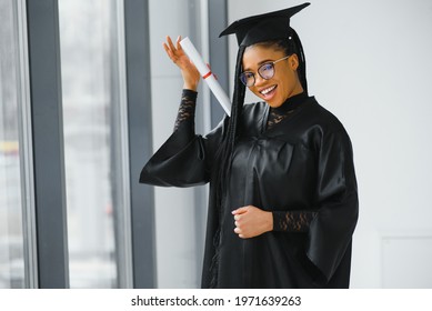 happy african american female student with diploma at graduation