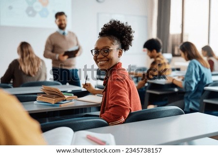 Happy African American female student on a class at the university looking at camera.