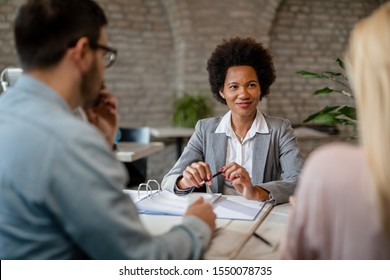 Happy African American Financial Advisor Having A Meeting With A Couple In The Office. 